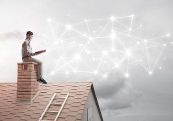 Man on brick roof reading book and concept of social connection