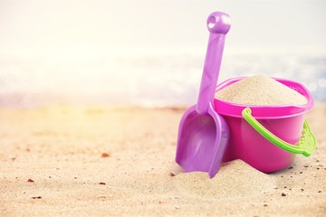 Colored toys on sandy seacoast. Travel concept