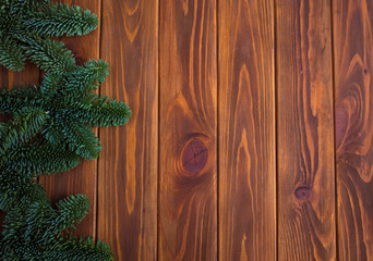 Christmas tree branch on wooden table. Top view with copy space
