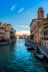 Fototapeta na wymiar Venezia con tipico scorcio con canale e barche in ambientazione diurna