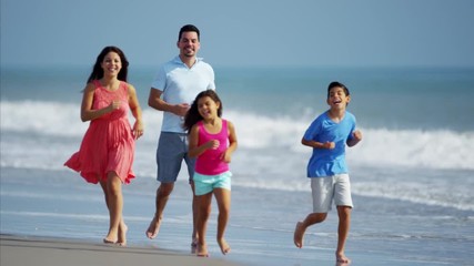 Happy Hispanic family spending leisure time on the beach outdoors