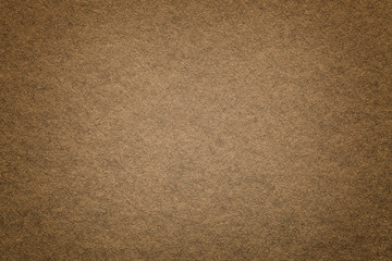 Texture of old dark brown paper background, closeup. Structure of dense cardboard.
