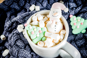 Creative idea for christmas drink, delicious hot chocolate with funny marshmallow snowman, christmas tree, rain dear, santa, on home background with xmas decoration copy space top view