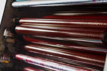 Rolling shafts in the paint of industrial printing machine. Offset printing.