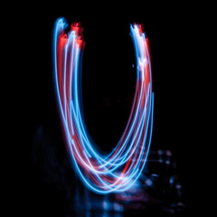 Letter U of the alphabet made from neon sign. The blue light image, long exposure with colored...