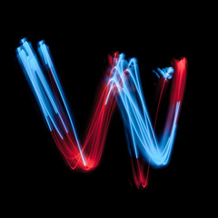 Letter W of the alphabet made from neon sign. The blue light image, long exposure with colored...