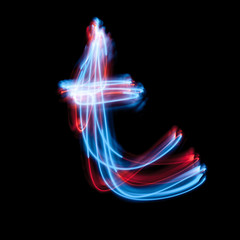Letter T of the alphabet made from neon sign. The blue light image, long exposure with colored fairy lights, against a black background