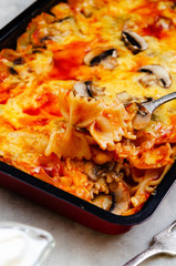 Baked pasta with mushrooms in tomato sauce, selective focus