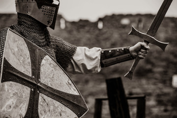 Closeup view on traditional medieval knight with shield and sword. Image in black and white color...