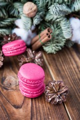 Pink macaroons with christmas decorations on wood