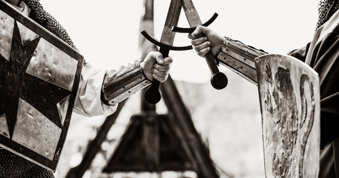 Closeup view on traditional medieval knights with shields and swords. Image in black and white color style