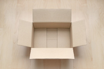 Empty open rectangular cardboard box on wood. Shopping online object background. Shipping parcel object.