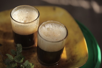 close up of traditional african tea - black strong green attaya in small glasses on a yellow plate, outdoors in the Gambia, Africa