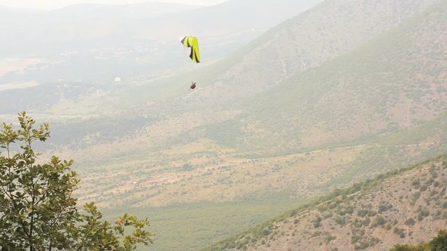 para glider flying a yellow parachute