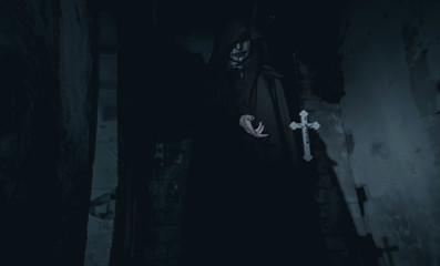 Woman is standing in a darkness next to the cross flying in the air in an image of a nun possessed...