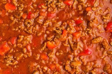 Cooking, ground meat, red bell pepper, onion, garlic, tomato sauce in pan, top view