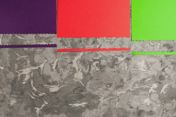 Three blank papers red and green and violet color with figured cutted border on old gray concrete surface with copy space. Top view. Education concept