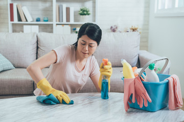 asian housewife wiping hard on marble table