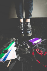 Young alternative girl on the black floor with a school bag