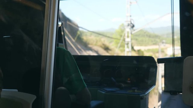 Unrecognizable train driver drives electrical train among mountain road. Point of view from driver cabin to railway tracks. Rear back view POV Slow motion Close up