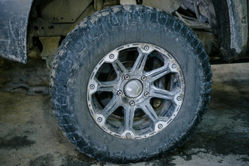 Fototapeta na wymiar big dirty wheel on the drive from the jeep