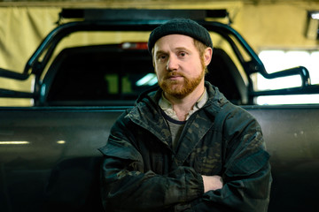 Portrait of a man with a beard near a pickup truck