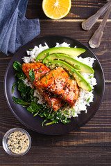 Salmon teriyaki rice bowl with spinach and avocado. View from above, top studio shot