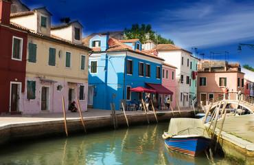 Fototapeta na wymiar Beautiful Burano in Venice. Colored houses along a dramatic sky channel
