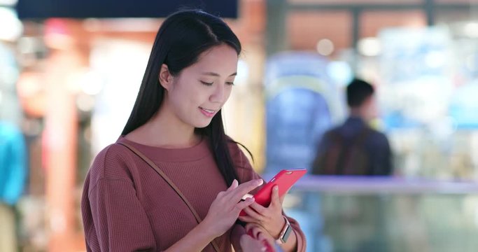 Woman checking discount pn cellphone inside shopping mall