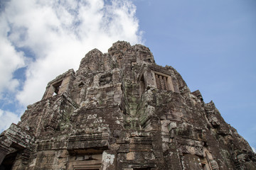Fototapeta premium Ancient temple name Bayon with stone faces in Angkor Thom, Siem Reap, Cambodia. Bayon's most distinctive feature is the multitude of serene and smiling stone faces on the many towers.