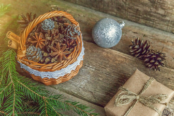 Christmas New Year composition with gift box fir branch basket pine cones on old shabby rustic wooden background. Xmas holiday december decoration to Russian tradition. Flat lay, copy space