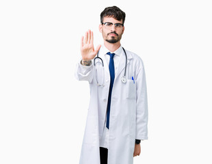 Young doctor man wearing hospital coat over isolated background doing stop sing with palm of the hand. Warning expression with negative and serious gesture on the face.
