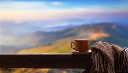 Keuken foto achterwand Thee Warme kop thee of koffie op de houten reling op de achtergrond van de bergen.