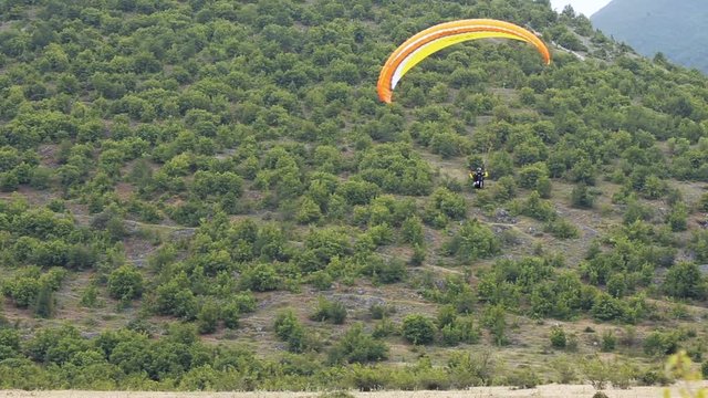 para glider flying an oragne parachute