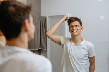 man making his hair in bathroom
