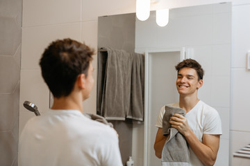 man holding towel in bathroom