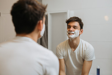 teenager shaving in bathroom