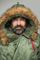 Handsome man with a beard in parka hood © HotPhotoPie