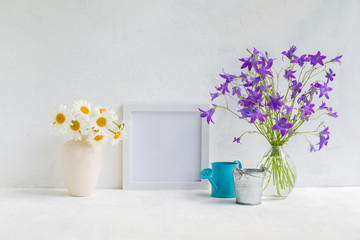 Mockup with a white frame and summer flowers in a vase
