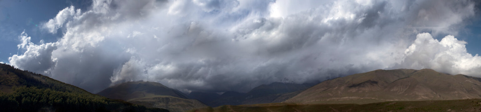 Mountains with white clouds. Pastures.