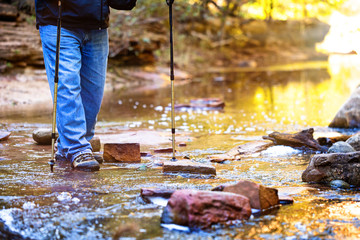 Man Crossing River on Hiking Path