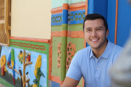 Man smiling close to building with colourful zocalos