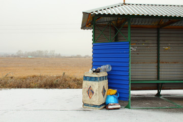 Naklejka premium Bus stop on the highway. Urn clogged with garbage. Background.