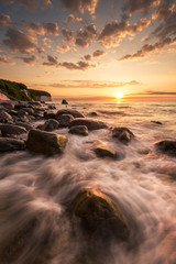 Rügen - Sonnenaufgang (Piratenbucht) - Wasser Strömung und Felsen mit leuchtenden Wolken und Sonne- Langzeitbelichtung