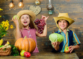 Children near vegetables wooden background. Elementary school fall festival idea. Kids girl boy wear hat celebrate harvest festival rustic style. School festival holiday. Celebrate harvest festival