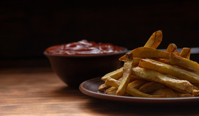 French fries on wooden table Selective focus, low key.