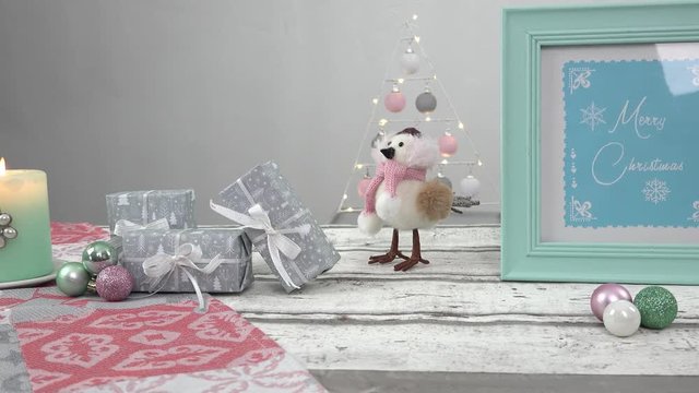Eine Kamera f&auml;hrt entlang Pastell farbiger Weihnachtsdekoration. Im Rahmen steht ein Schild im Stil von Hand lettering mit dem Text: merry christmas.