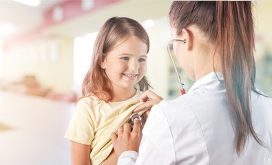 Young  doctors with little girl on  background