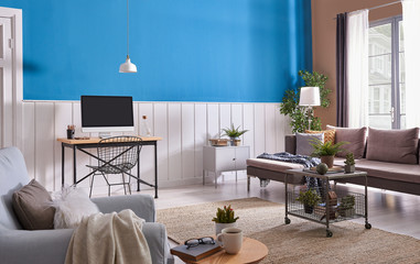Fototapeta premium Grey sofa and blue armchair in living room with lamp blue white wall.