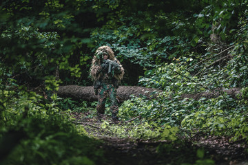 Camouflaged soldiers in forest during summer on patrol	